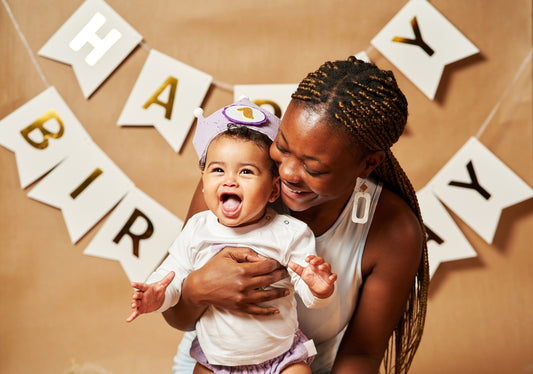 African-American woman holding their child and celebrating baby’s first birthday