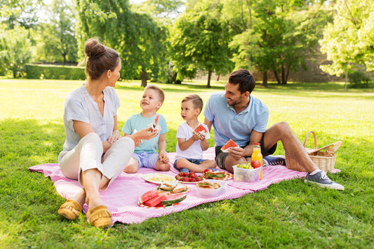 Woman and man enjoying a family picnic outdoors with their two children 