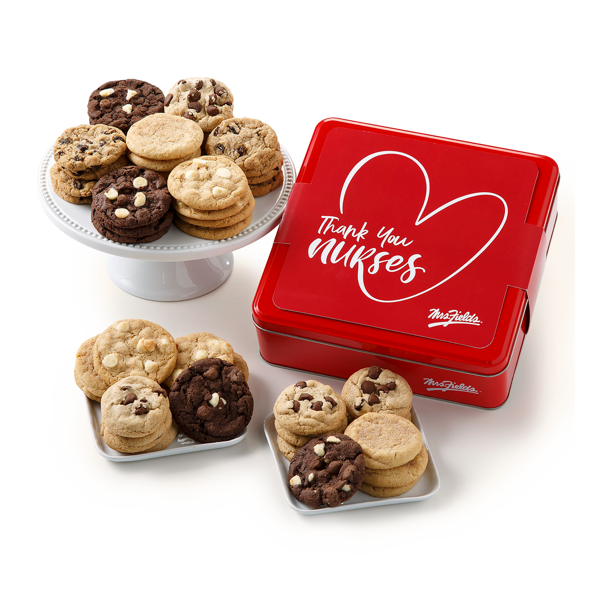 A red metal gift tin with white script reading 'Thank you Nurses' and the Mrs Fields logo, shown with assorted cookies on small plates and a cake stand against a clean white background.