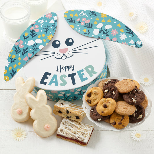 A bunny gift box surrounded by an assortment of nibblers, fruit bars, and frosted bunny cookies