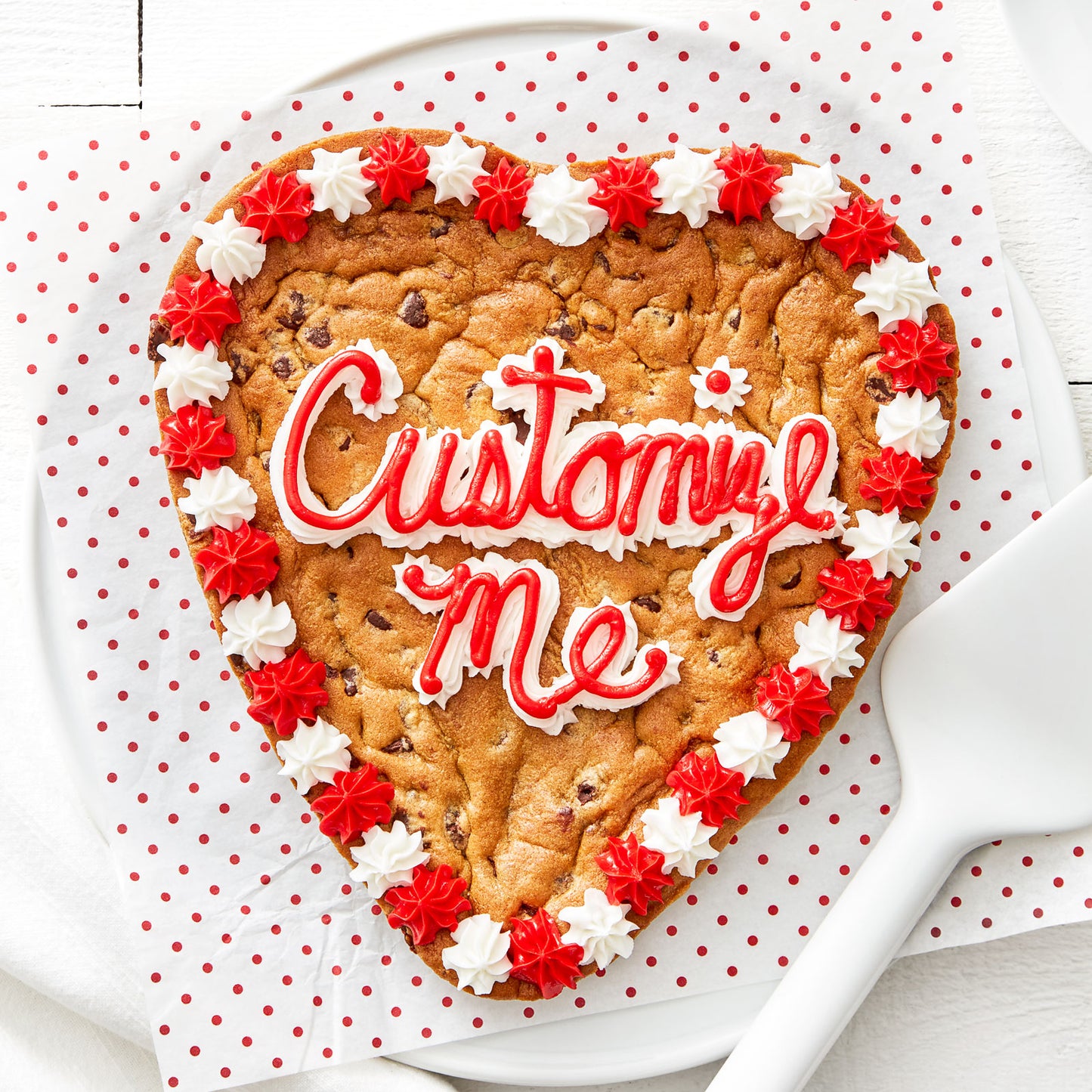 Red and white frosting saying customize me on heart shaped cookie cake