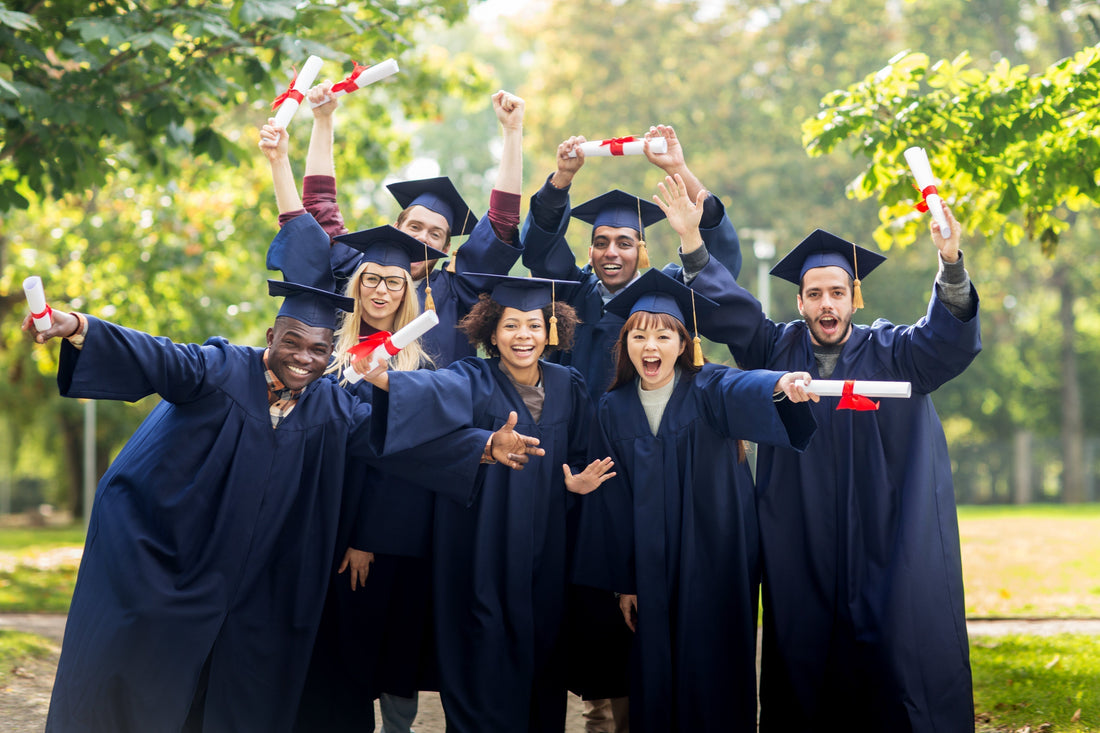 Excited graduates posing for a picture with diplomas in hand 