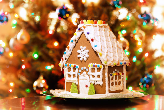 gingerbread house with festive christmas tree lights in the background