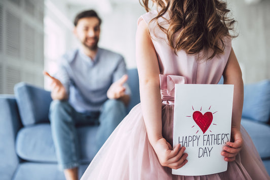 A man waiting for his young daughter to surprise him with a happy Father’s Day card she made
