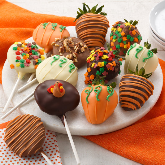 An assortment of fall themed chocolate covered strawberries and Nibblers® pops