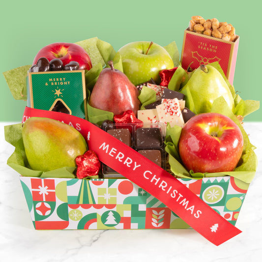 A decorated holiday crate filled with an assortment of fruit, nuts, and chocolate with a red "Merry Christmas" ribbon.