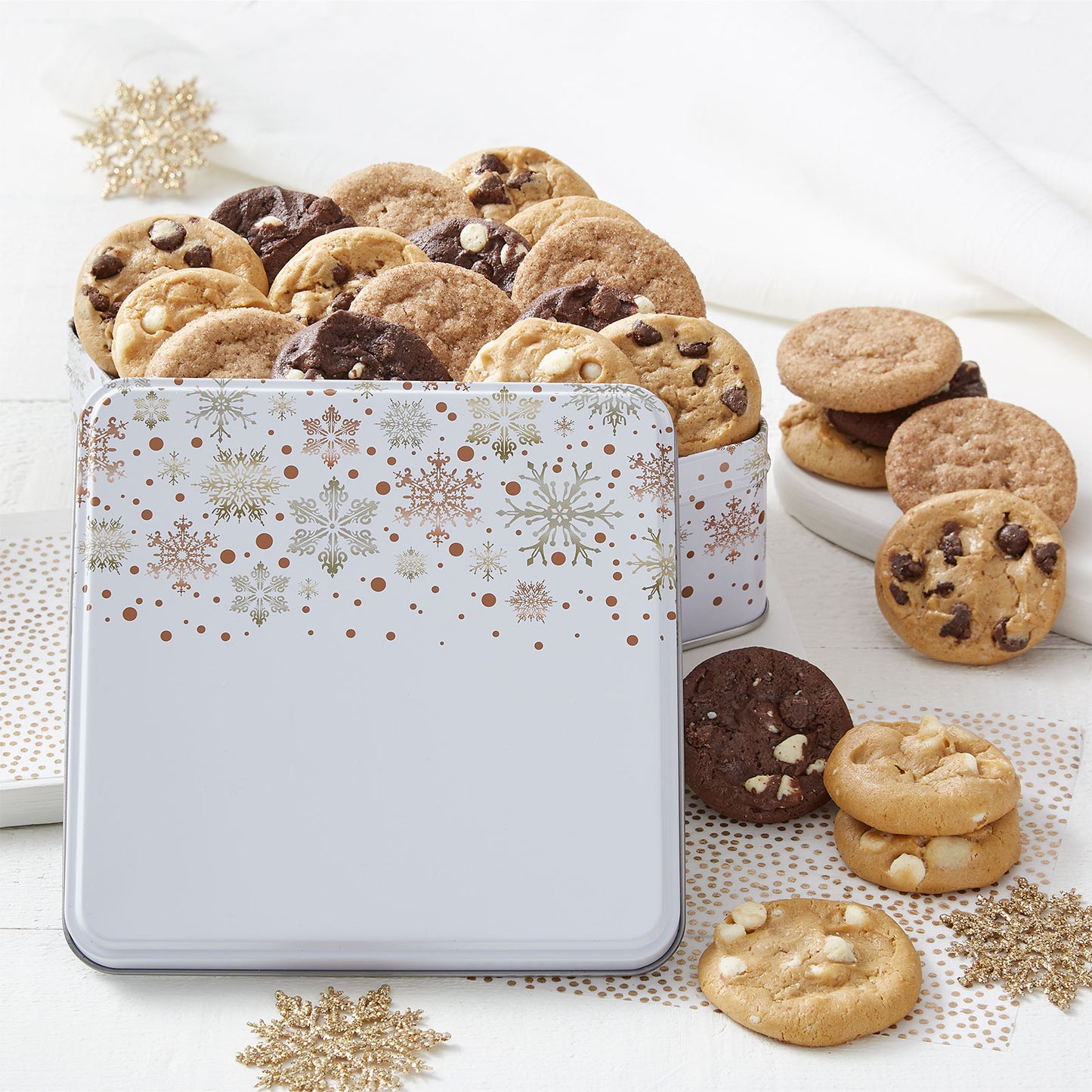 Silver and Gold snowflakes on a white tin filled with an assortment of Nibblers®