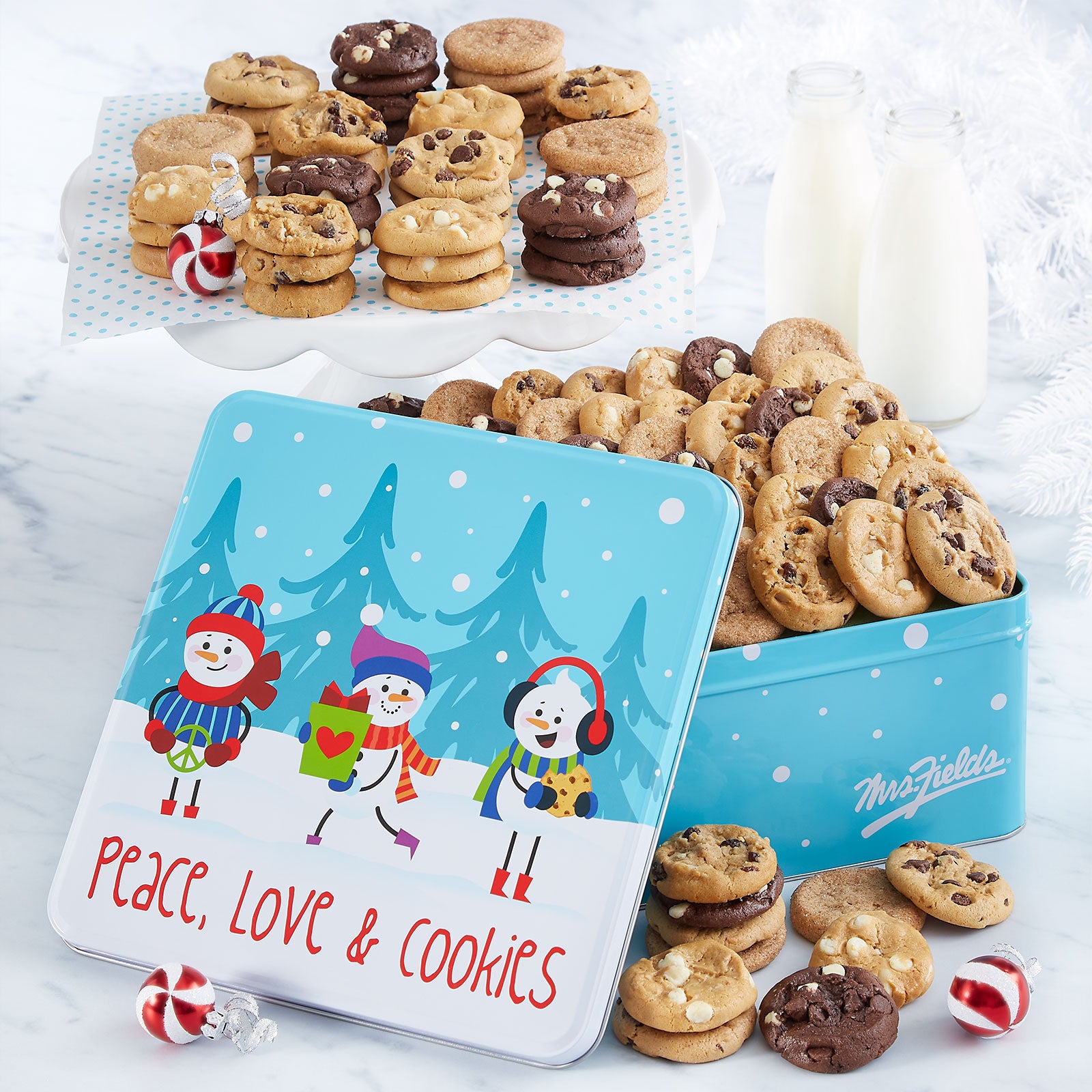 Peace, Love and Cookies sentiment on a gift tin with snowman friends as decorations. This tin is filled with an assortment of Nibblers®