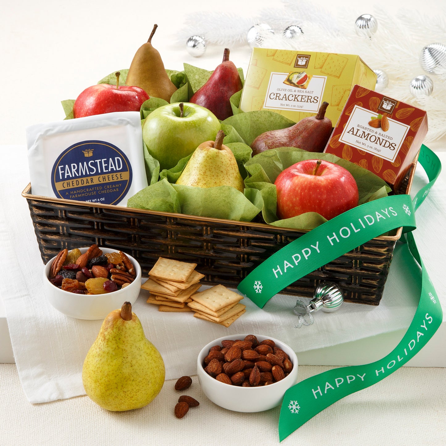 A brown basket filled with an assortment of fruit, nuts, cheese, and crackers.