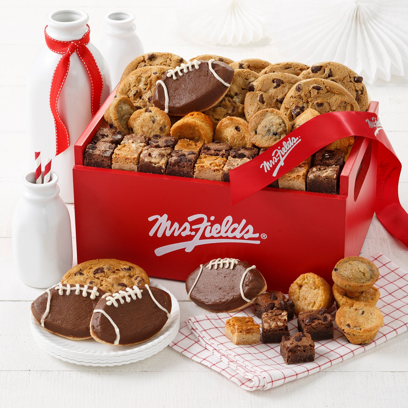 A signature Mrs. Fields red wood crate filled with semi-sweet chocolate chip original cookies, an assortment of brown bites, muffins, and four frosted football cookies
