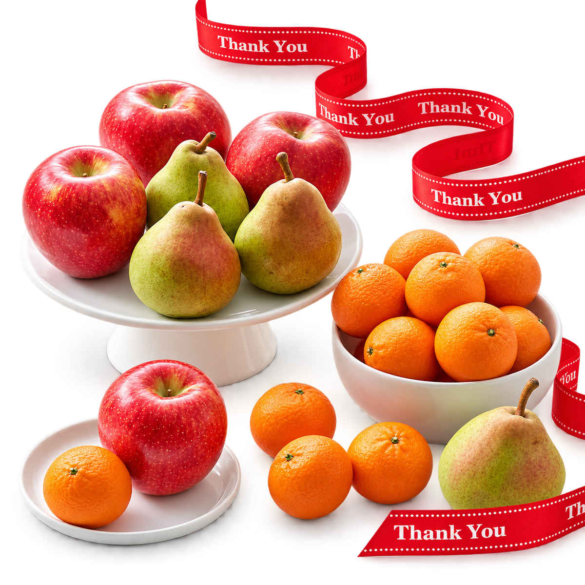 A styled fruit arrangement on white plates and a bowl, including red apples, green and yellow pears, and oranges, with red ribbon accents printed with the words 'Thank You'.