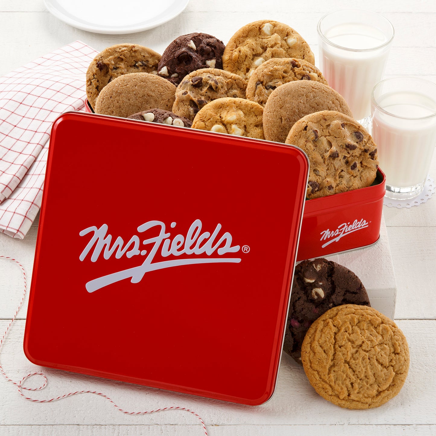 A signature red Mrs. Fields gift tin filled with an assortment of original cookies