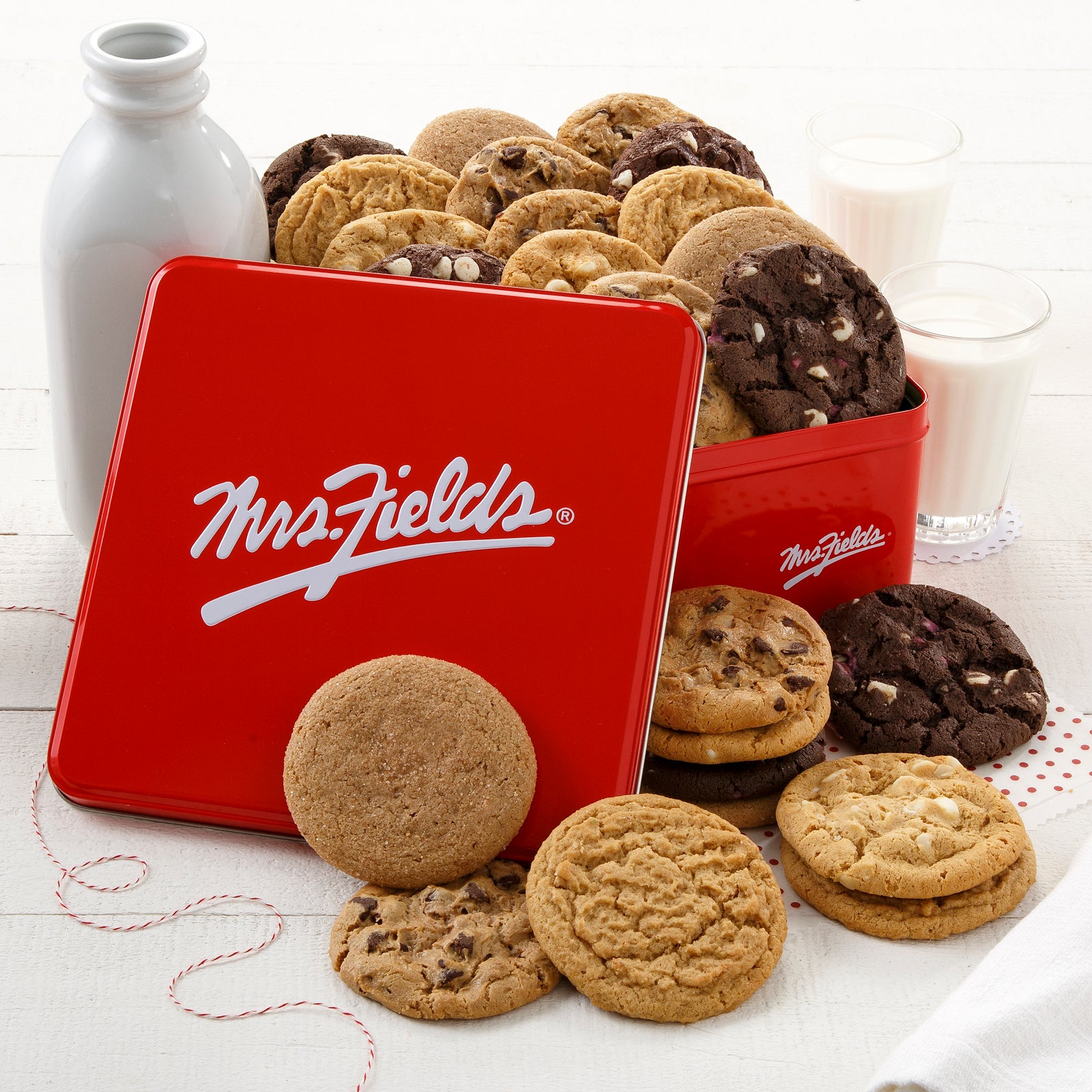 A red Mrs Fields gift tin filled with an assortment of two dozen original cookies