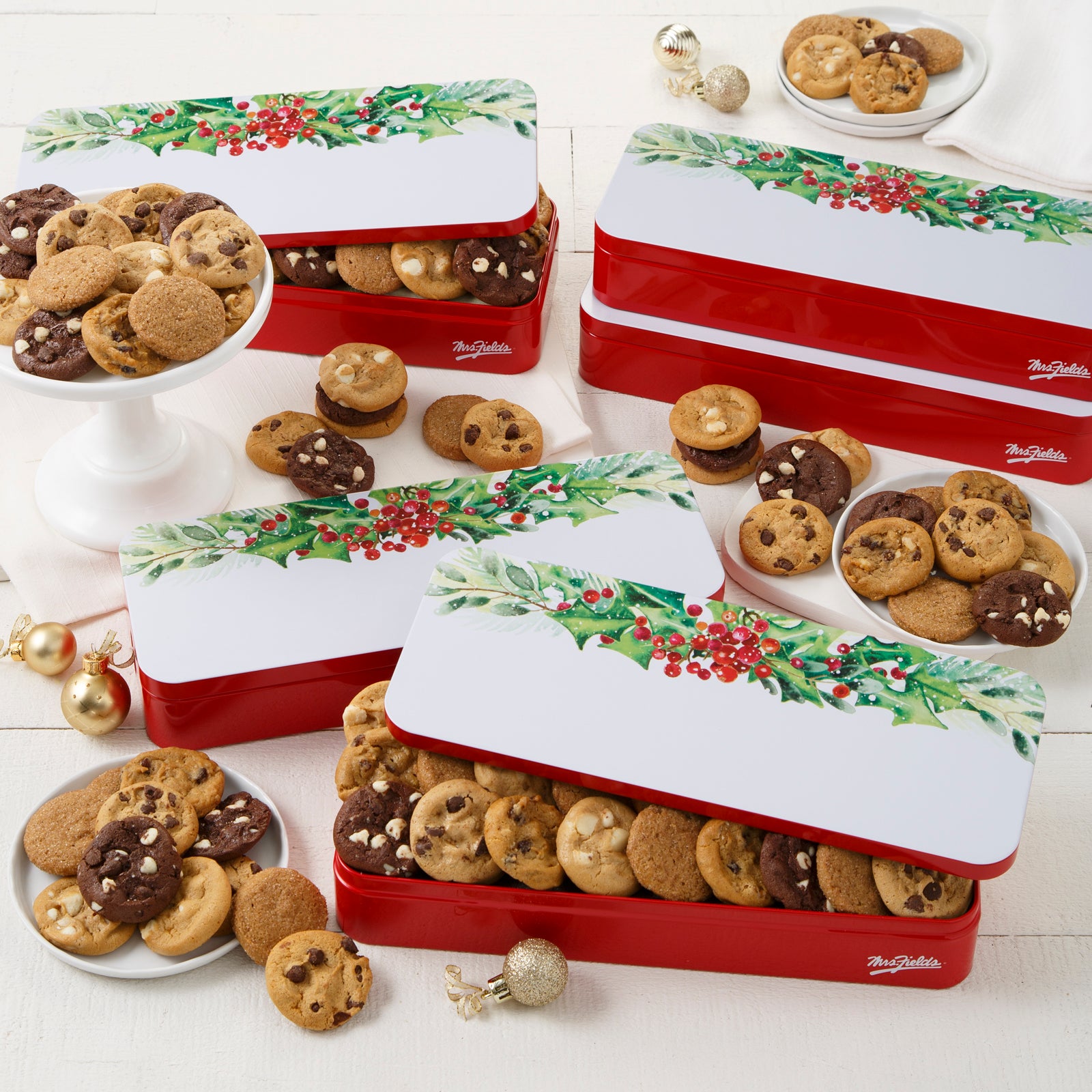 Four holly gift tins with an assortment of Nibblers®