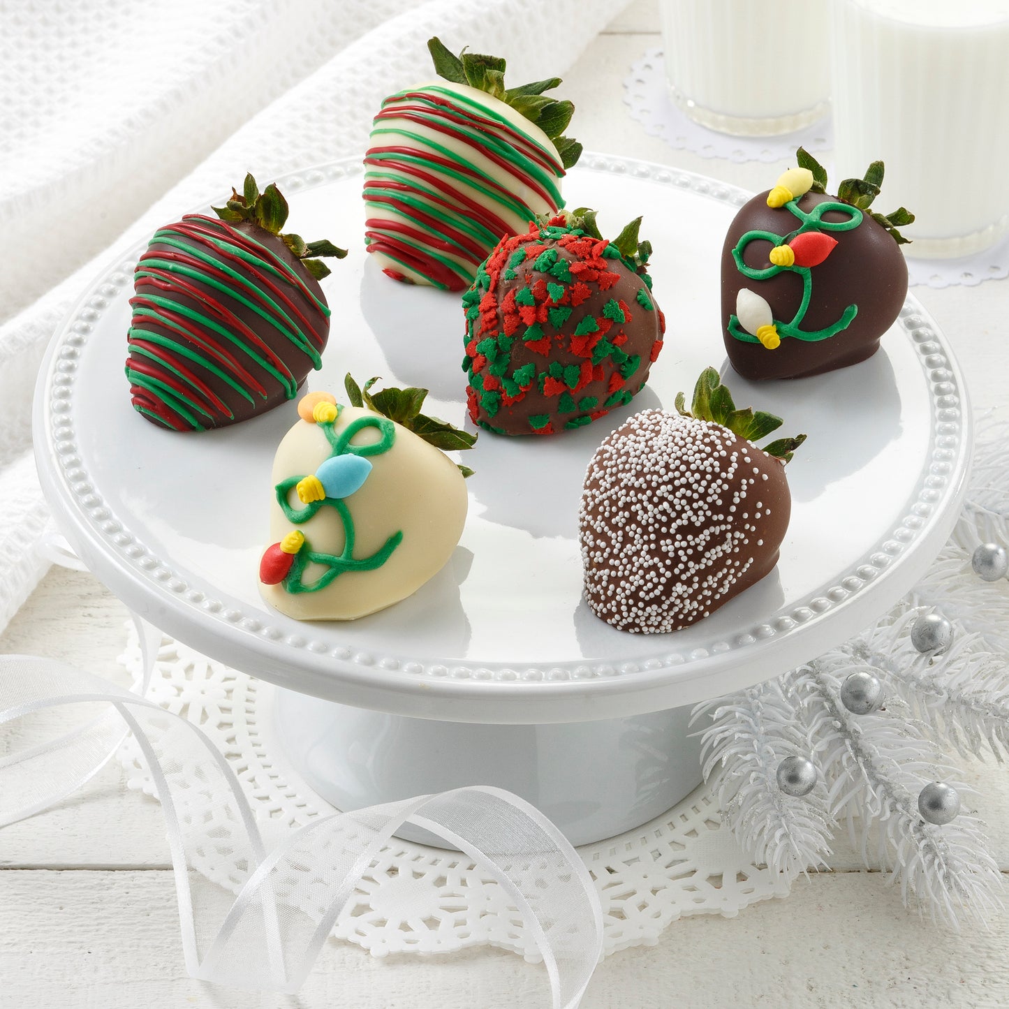 Six chocolate-covered strawberries decorated in a holiday theme