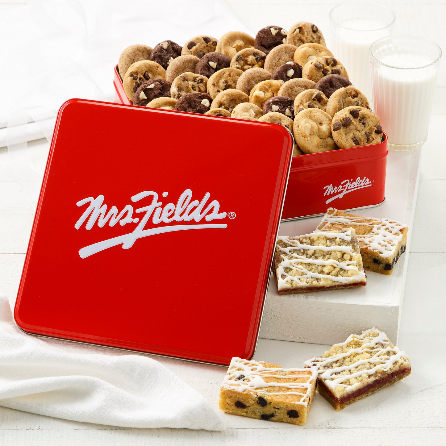 Mrs. Fields red signature tin fill with Nibblers® with four assorted fruit bars in front