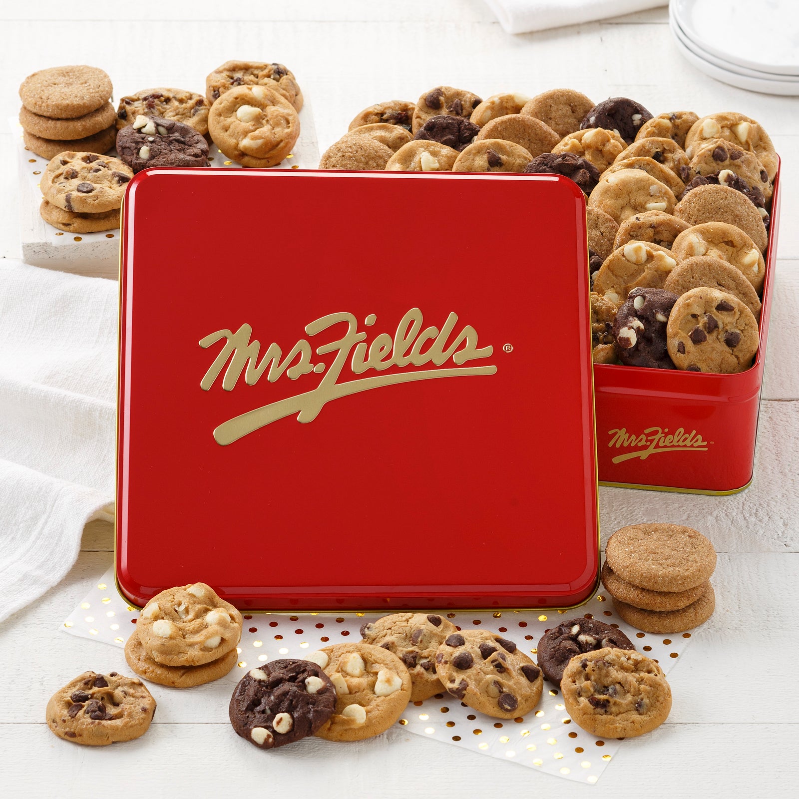 A red and gold signature 60 Nibbler tin filled with an assortment of Nibblers®