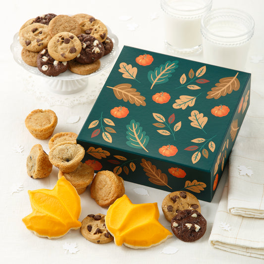 A green fall themed gift box with fall leaves surround by an assortment of Nibblers®, muffins, and frosted leaf cookies