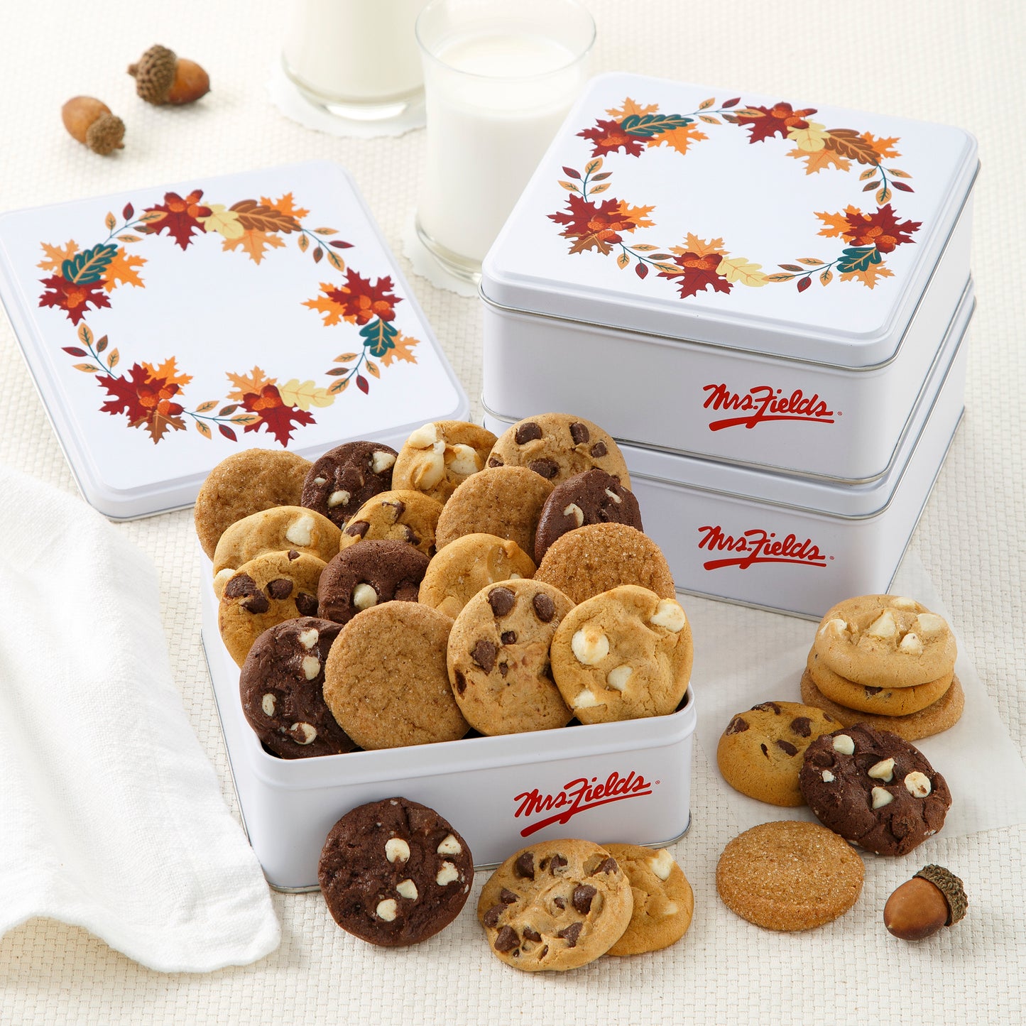 Three fall themed mini tins with one opened and filled with an assortment of Nibblers®