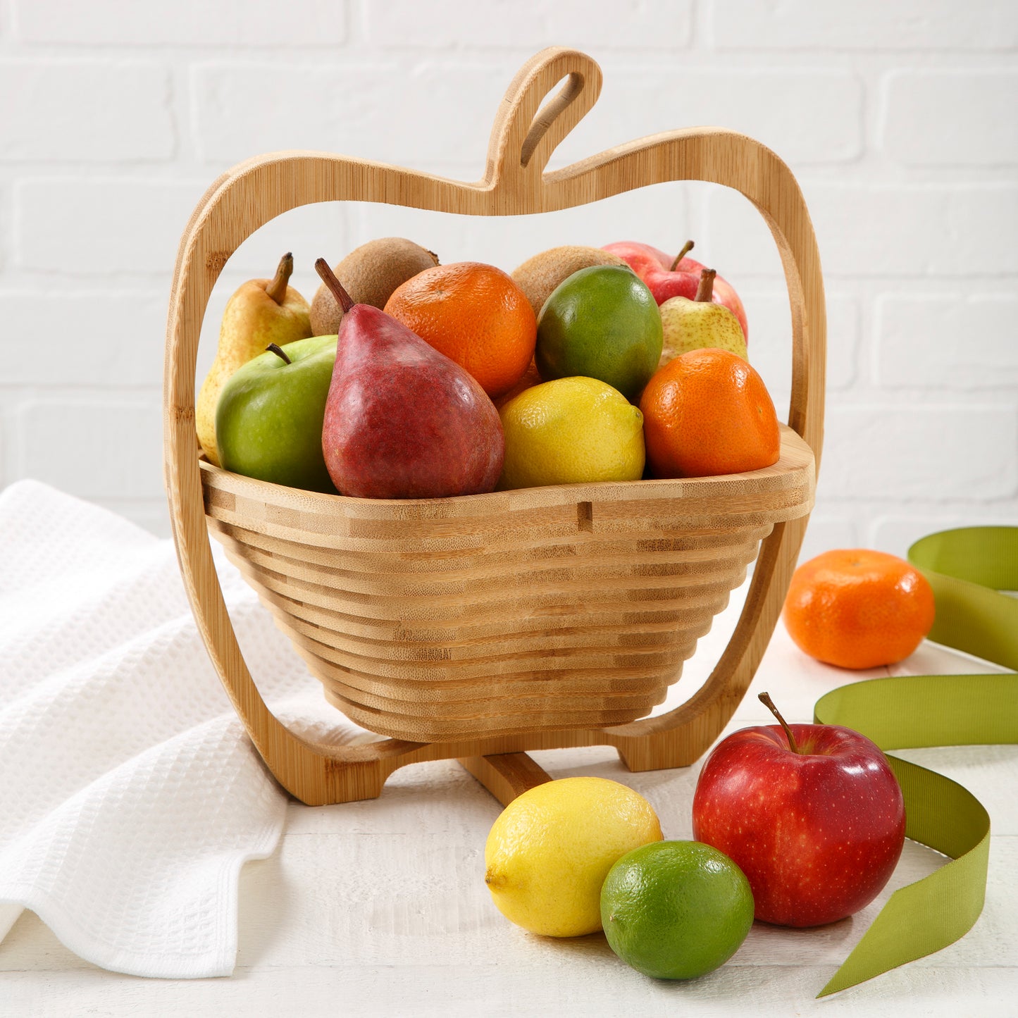 An apple shaped wooden basket filled with an assortment of fruit