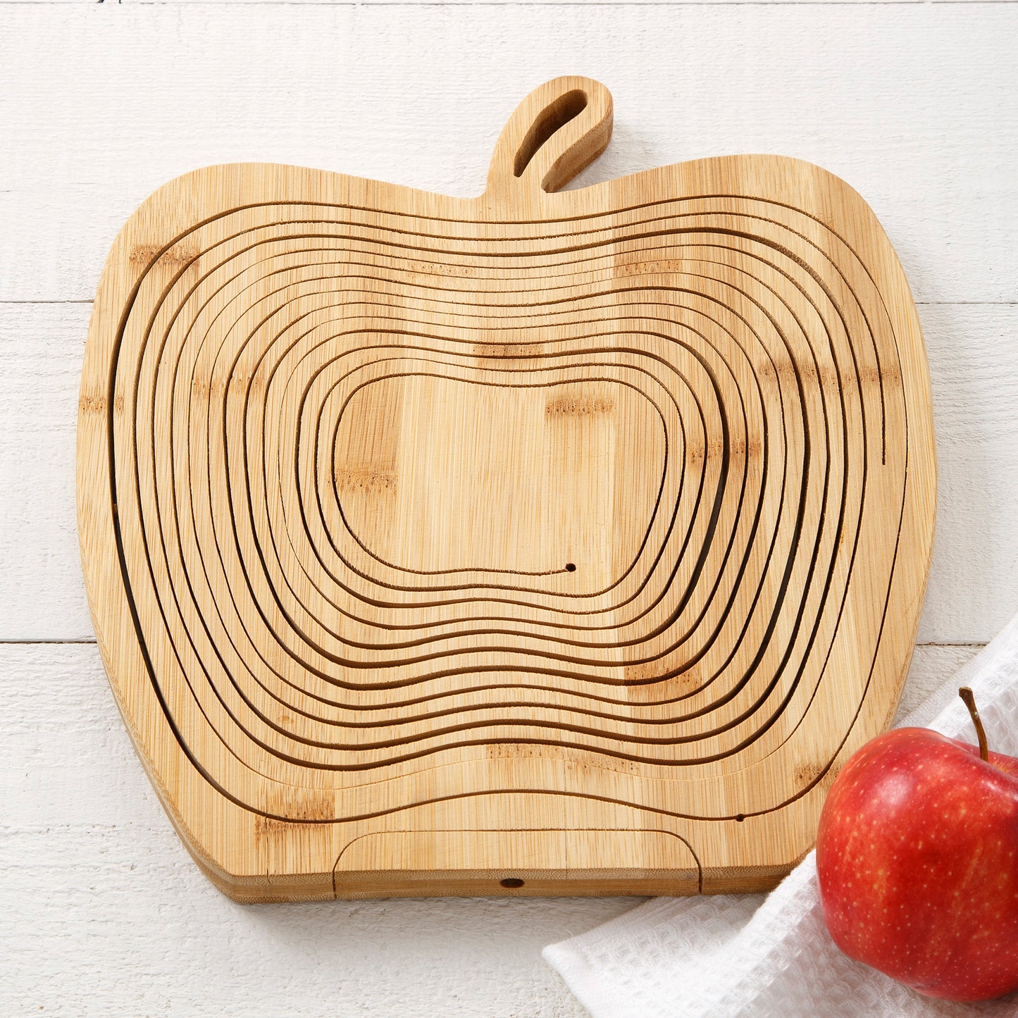 A collapsed apple-shaped wooden basket