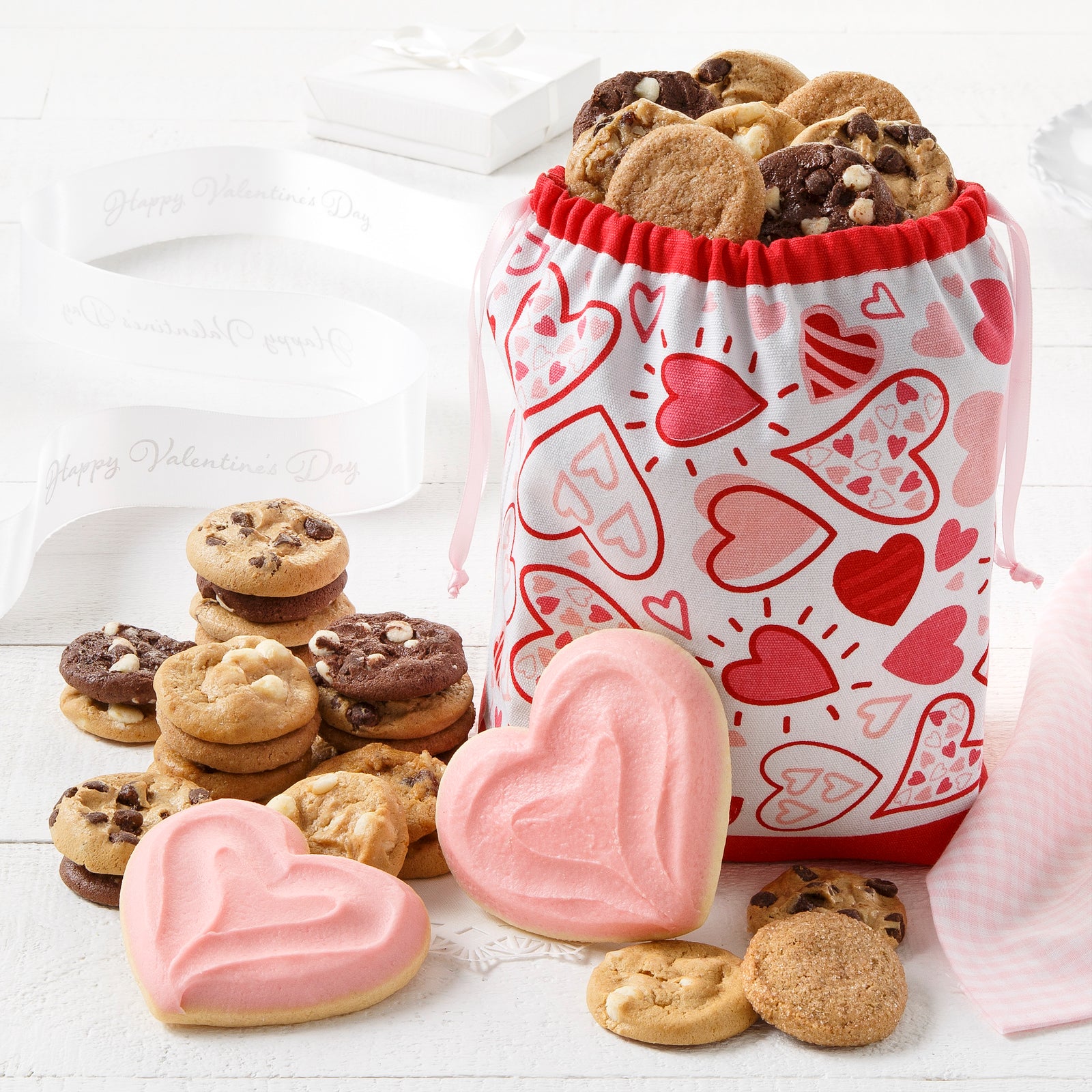 A heart tote filled with nibblers and two frosted heart cookies