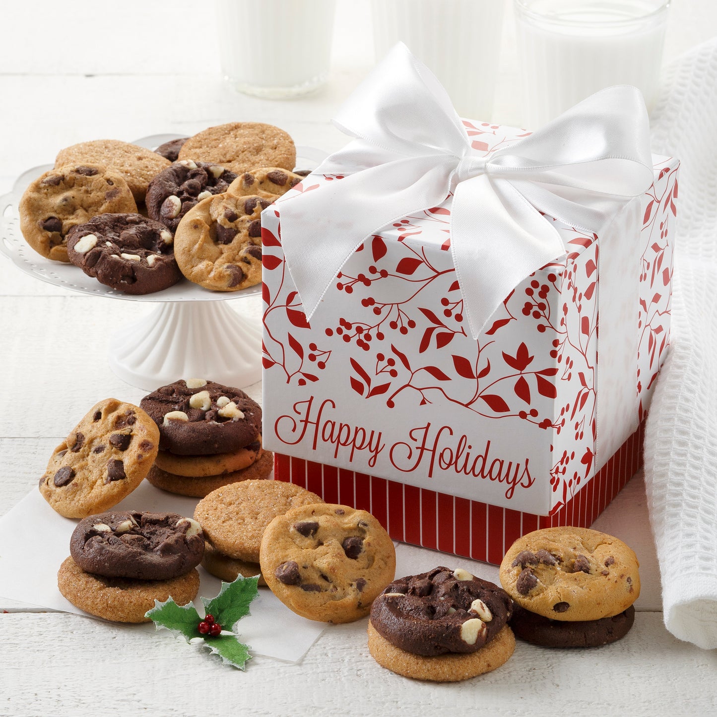 A Happy Holidays mini gift box decorated with holly and surrounded by nut free Nibblers®