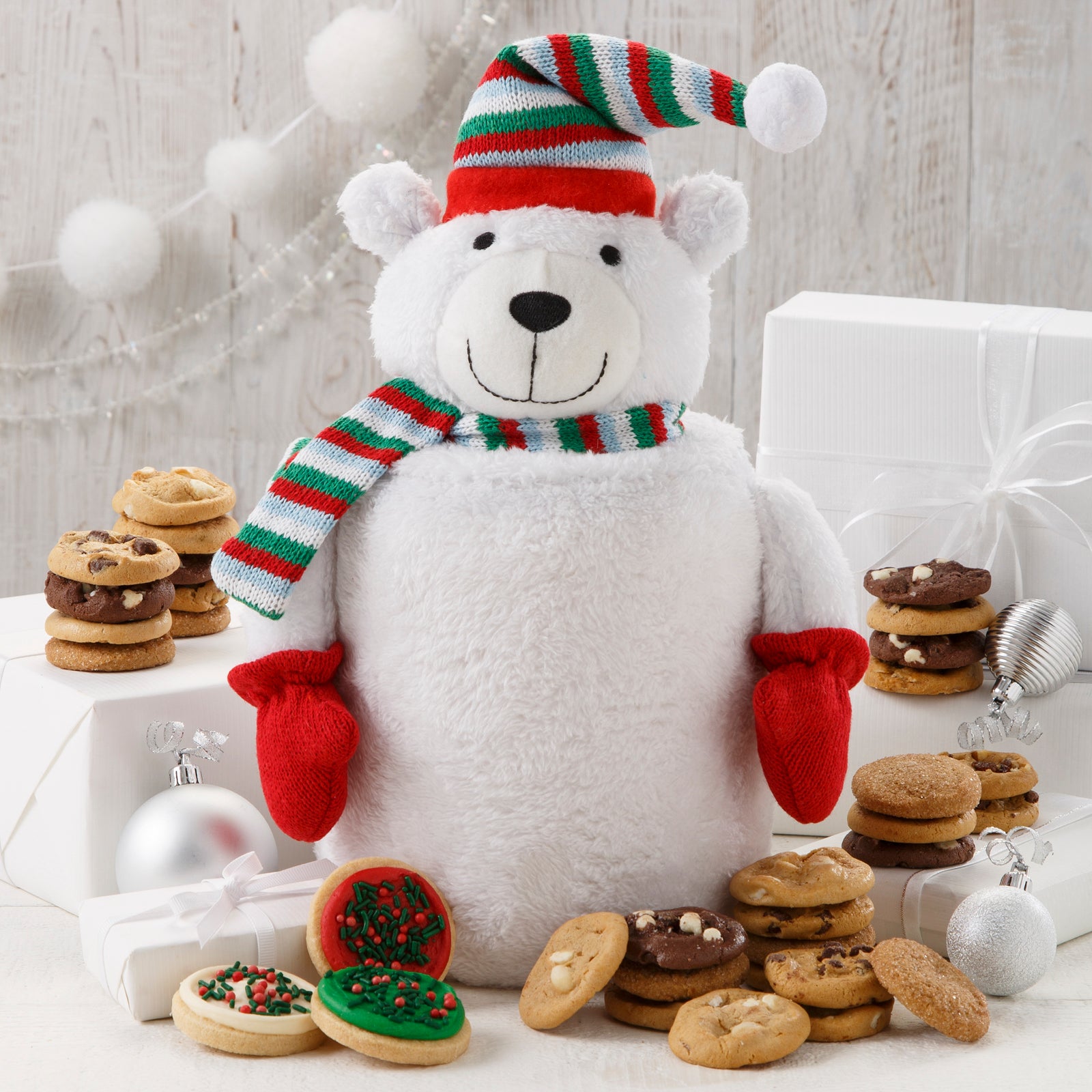 A fuzzy polar bear cookie jar surrounded by an assortment of Nibblers® and frosted mini-round cookies with sprinkles. 