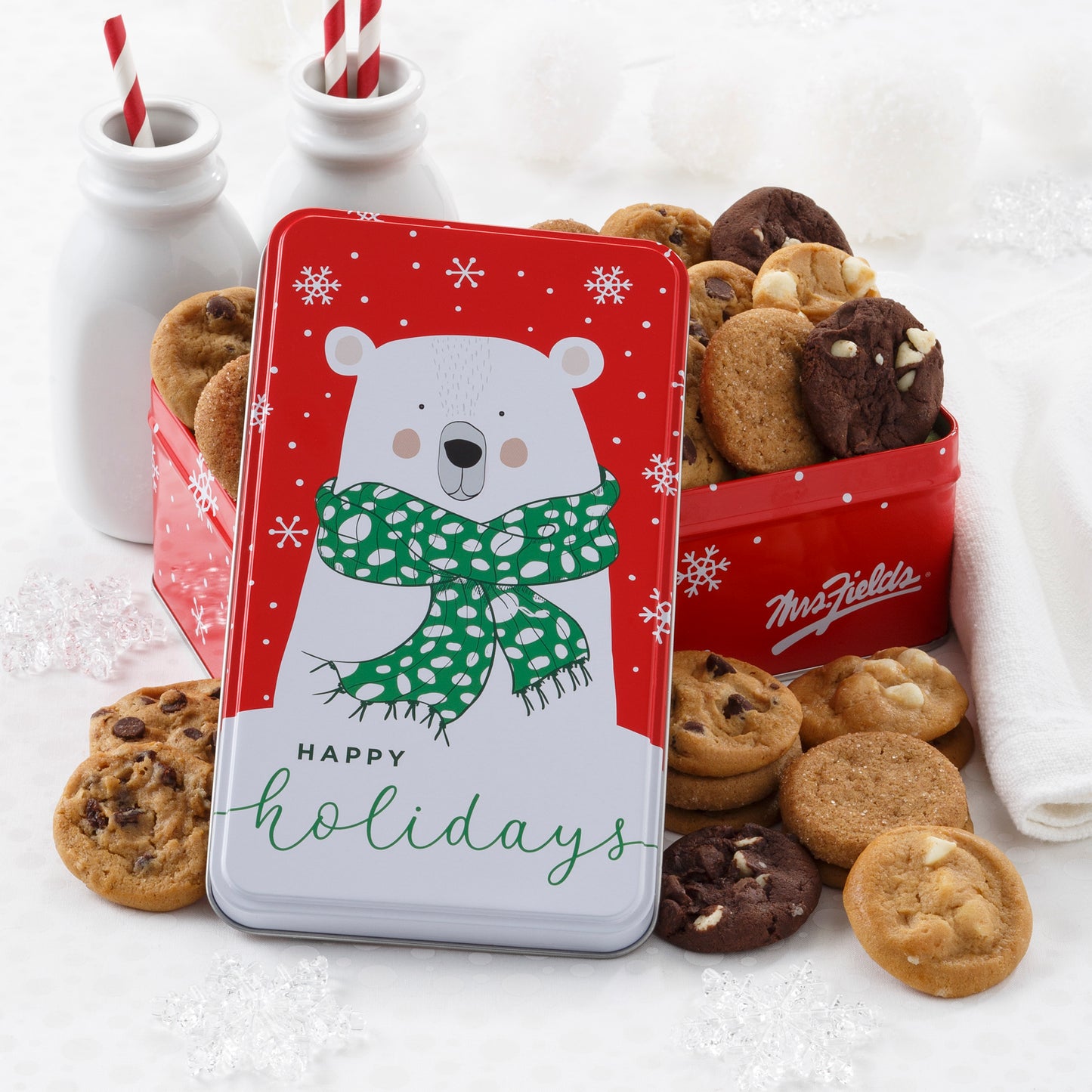 A Happy Holiday tin decorated with a polar bear and filled with an assortment of Nibblers®