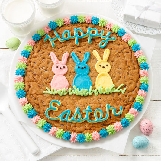 A cookie cake decorated with a Happy Easter sentiment and three bunnies
