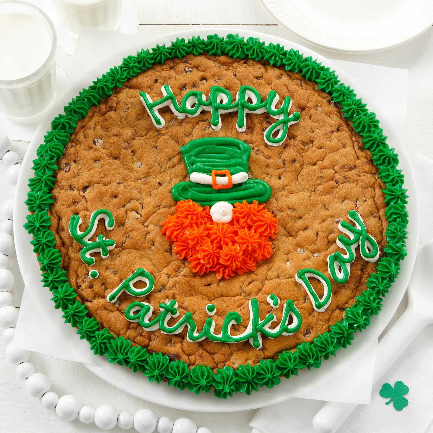 A Happy St. Patrick's Day cookie cake decorated with a frosted leprechaun face