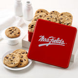 Mrs. Fields signature red cookie tin with a dozen semi-sweet chocolate chip cookies on a white surface with plates and milk bottles.