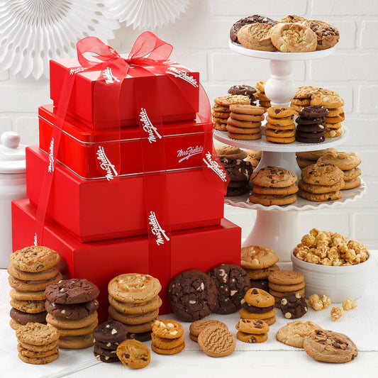 A stack of red boxes and a tin come filled with original cookies, Nibblers® Bite-Sized Cookies and toffee nut popcorn