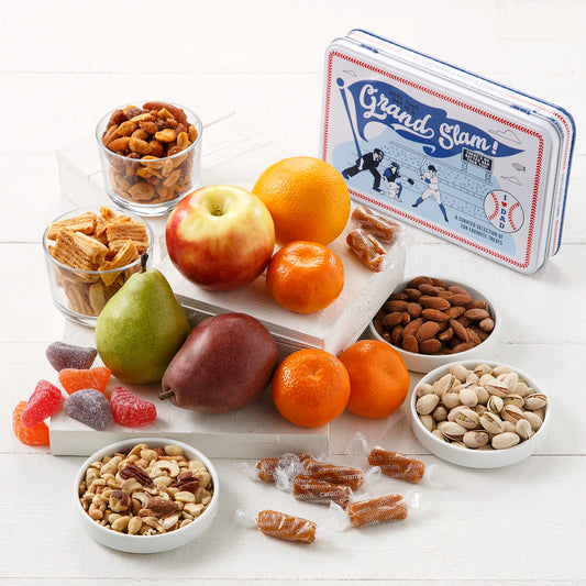 Assorted fruits, nuts, and candies on a white surface with a Father's Day and baseball themed 'Grand Slam! I (heart) DAD' branded tin.