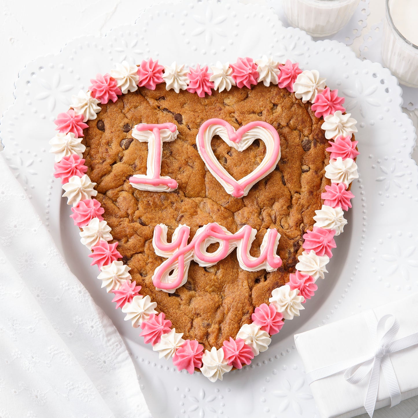 A heart-shaped cookie cake with an I Love You sentiment and decorated with pink and white frosting