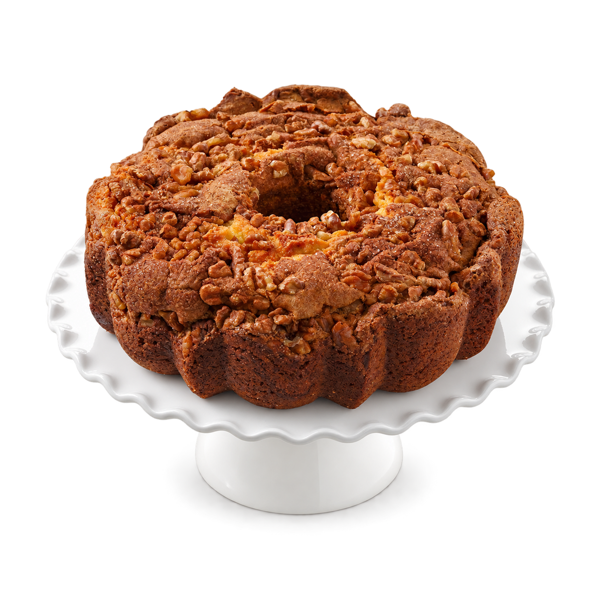 A ring-shaped cinnamon walnut bundt cake with a crumb streusel topping, presented on a white scalloped cake stand.
