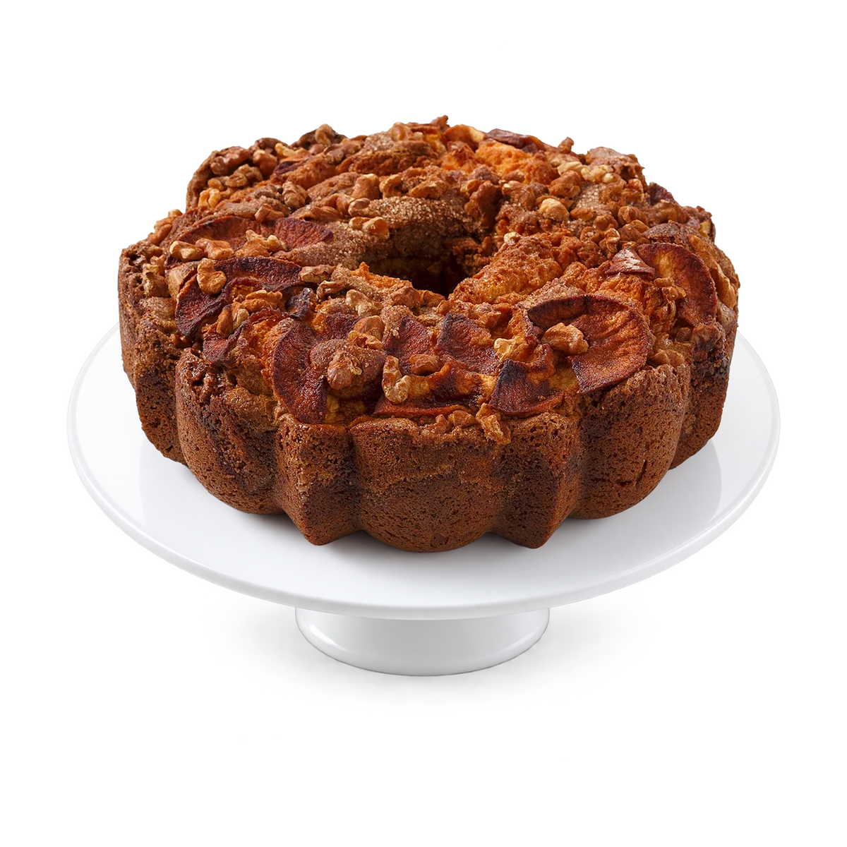 A ring-shaped apple-cinnamon-walnut bundt cake with a crumb topping and dried fruit slices, displayed on a white round cake stand.
