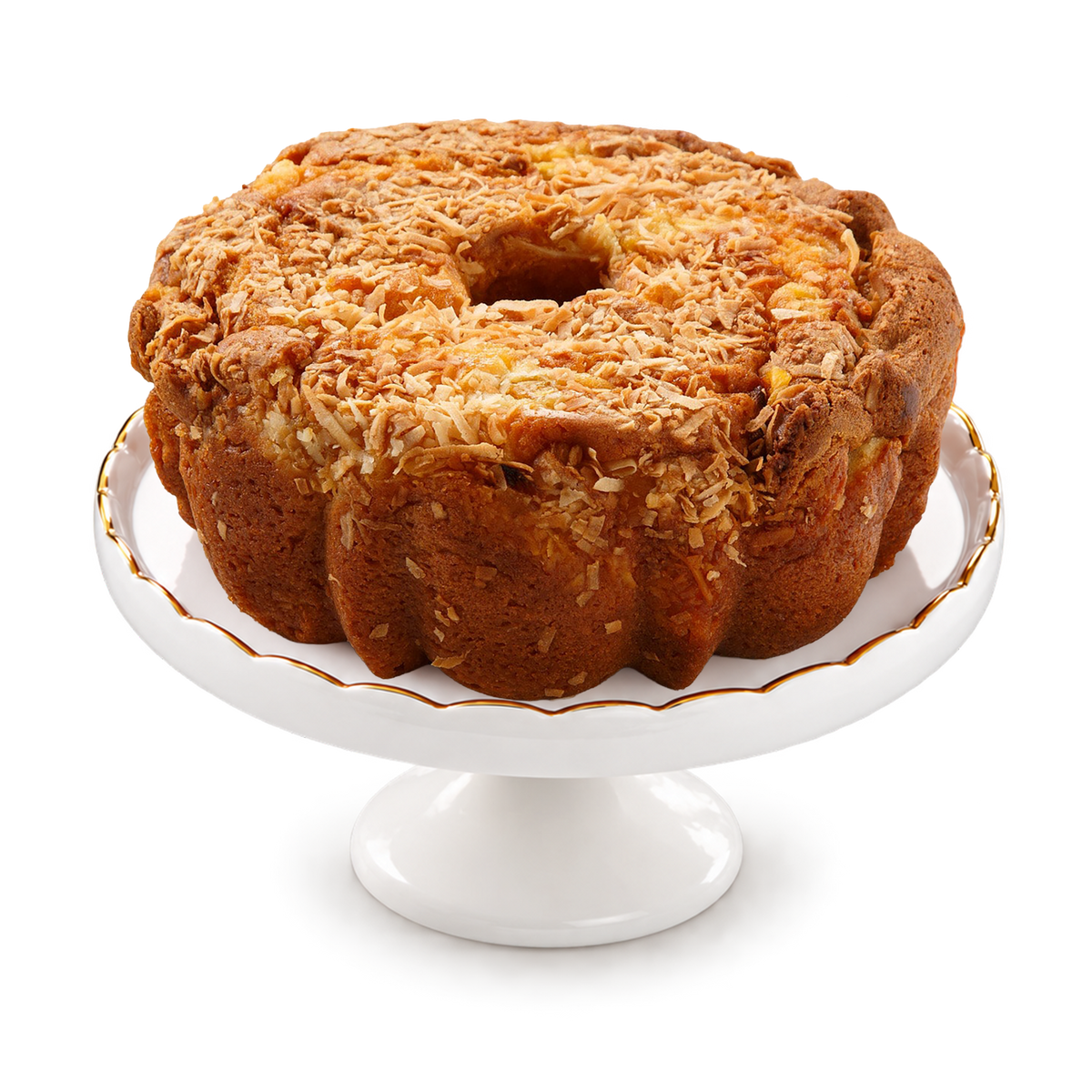 A golden-brown ring cake topped with shredded coconut, presented on a white ceramic cake stand with a thin gold rim, isolated on a white background.