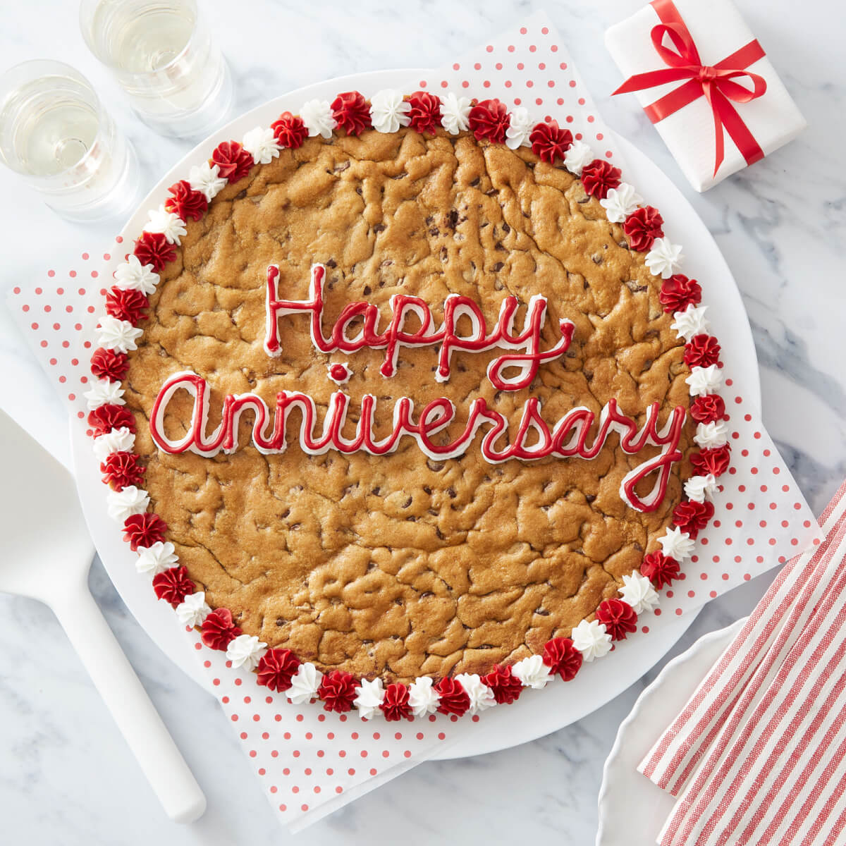 Custom cookie cake with "Happy Anniversary" written in red and white frosting