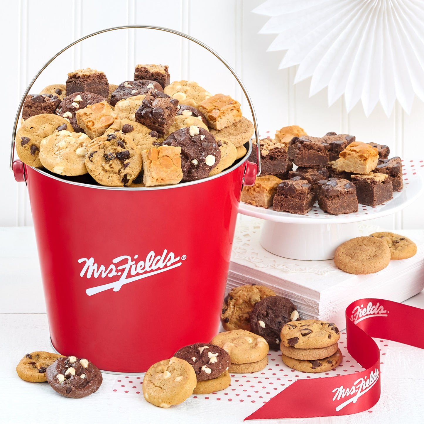 Red Mrs. Fields pail filled with an assortment of nibblers and brownie bites