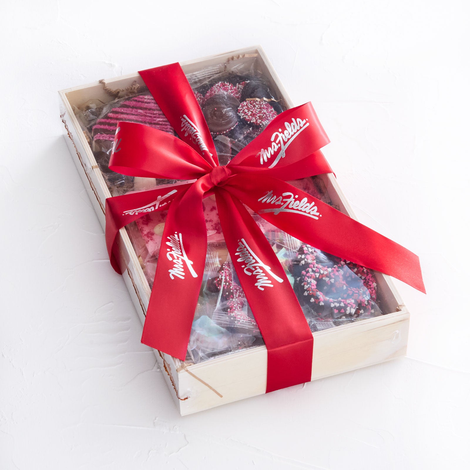 Valentine's Day themed chocolates and chocolate covered pretzels in a gift tray and tied with a red Mrs. Fields ribbon