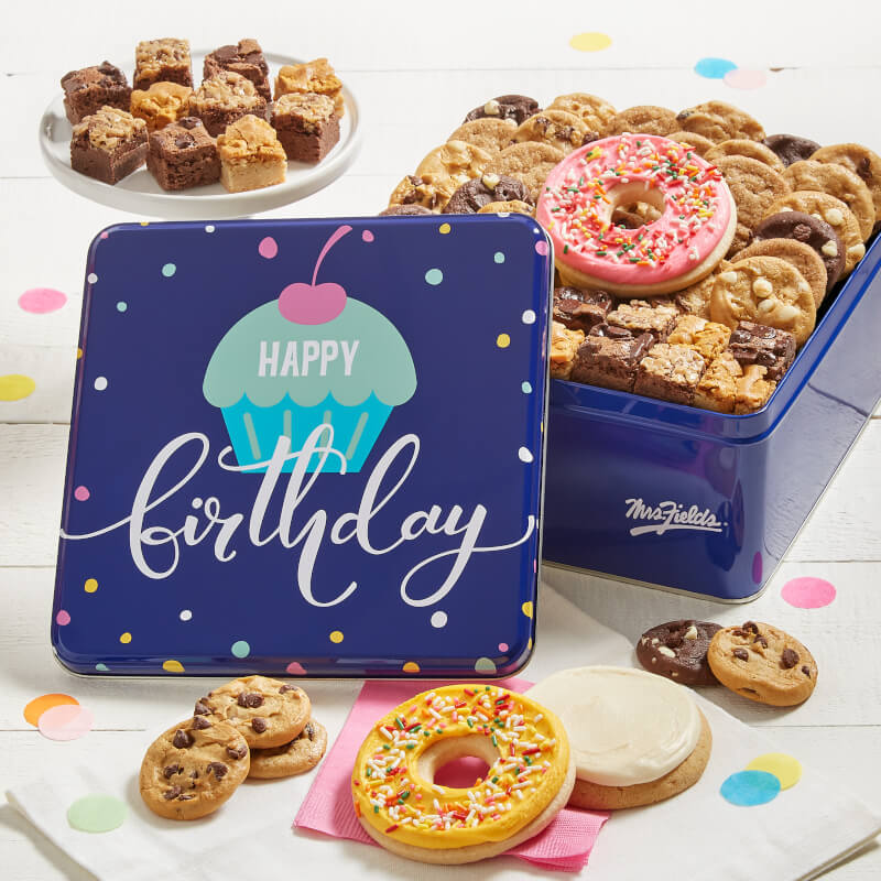 Assorted treats in a blue tin that says happy birthday