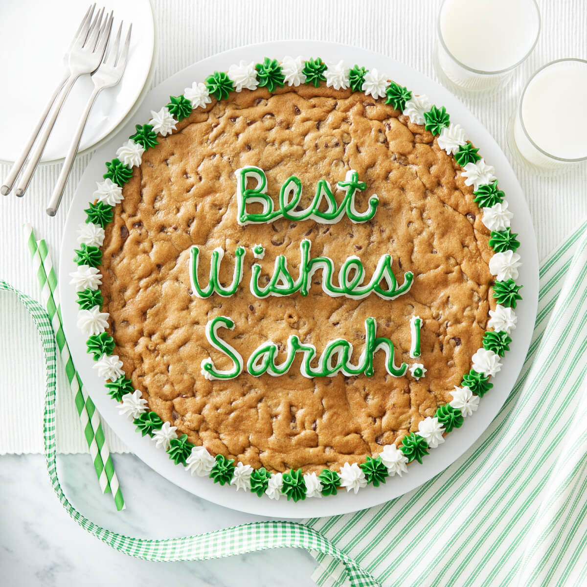 Cookie cake with "Best Wishes Sarah!" written in green and white frosting