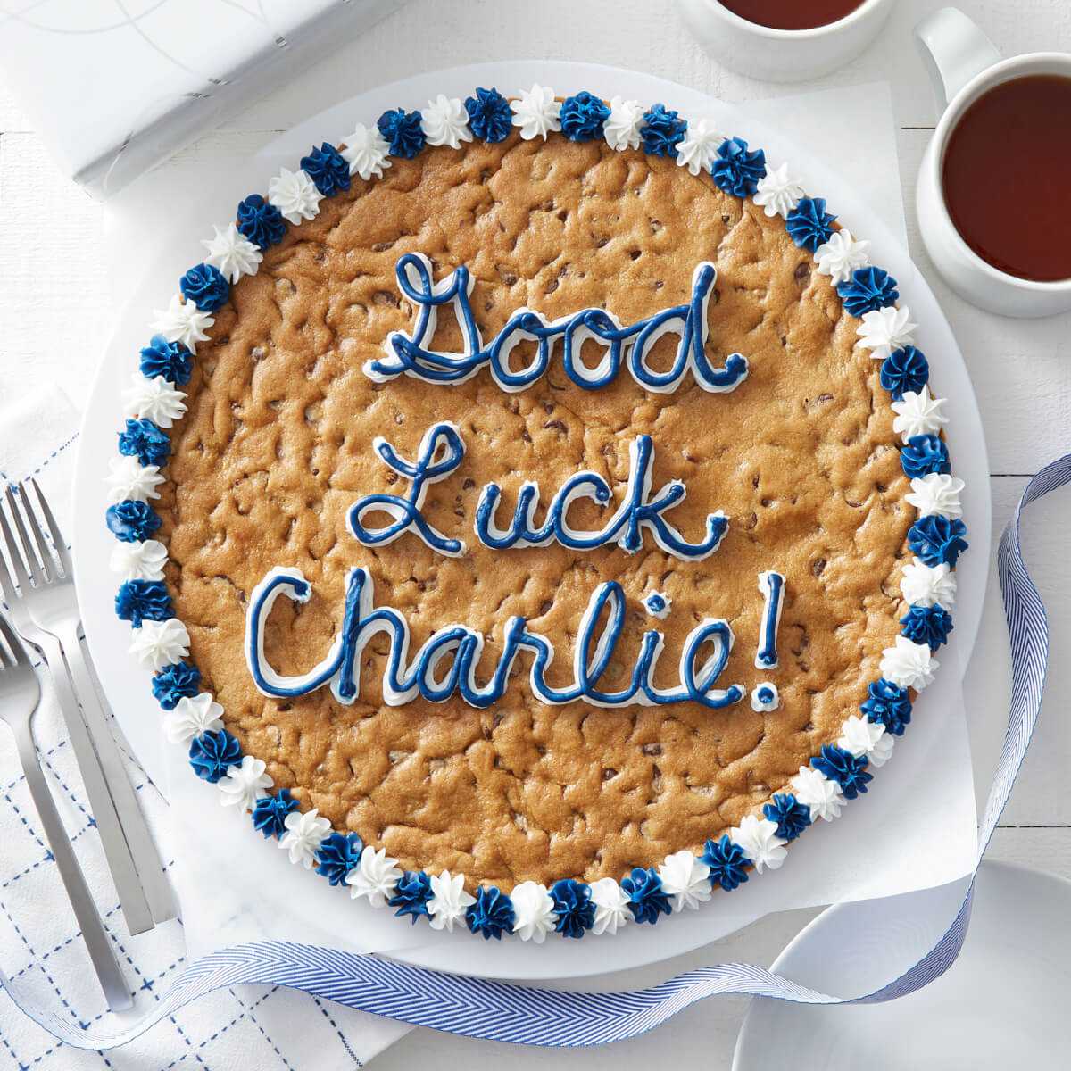 Custom cookie cake with "Good Luck Charlie!" written in blue and white frosting