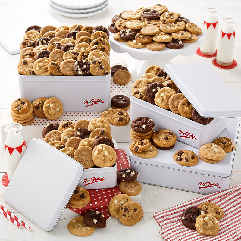 An assortment of multiple sized white gift tins filled with an assortment of nibblers
