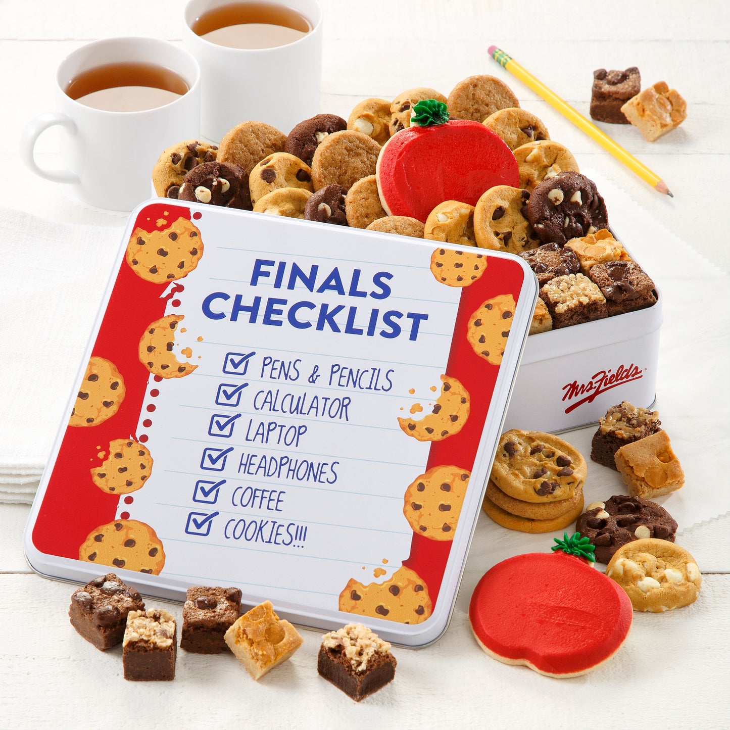 A school-themed gift tin with the sentiment Finals Checklist with a list that includes Pens & Pencils, Calculator, Laptop, Headphones, Coffee, Cookies. This tin is full of an assortment of Nibblers®, brownie bites, and two frosted apple cookies